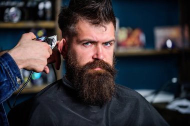 Kuaför saç kesme makinesi ile çalışır. Berber kavramı. Berber makası, elinde kapatın. Hipster sakallı istemci üzerinde katı yüz saç modeli almak. İstemci, berber arka plan olarak sakallı adam