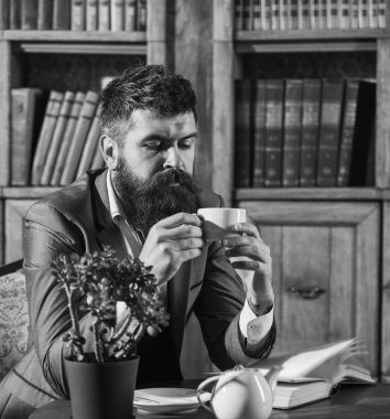 Kütüphanede okuyun. Oldfashioned adam çay Kupası tutar. Aristokrat yaşam tarzı kavramı.