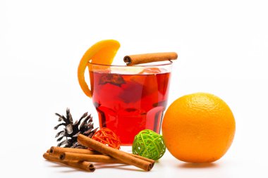 İçki ya da portakal ve tarçın ile içecek. Kış kokteyl kavramı. Cam mulled şarap veya portakal, tarçın ve çam kozalağı beyaz arka plan üzerinde yakın sıcak elma şarabı ile. Bardakta servis mulled şarap