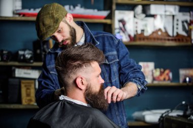 Sakal hipster istemcisinin damat ile meşgul berber, güzellik arka plan sağlar. Sakallı hippi şık berber dükkanı olarak profesyonel kuaför tarafından hizmet veren cape kaplı. Damat kavramı