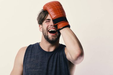 Tüylü ve gülen yüzlü adam boks eldiveni giyiyor.