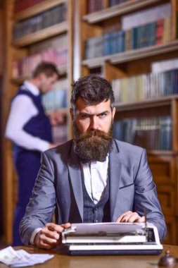 Raflardan arka plan üzerinde yeni bir kitap üzerinde çalışan yazar.