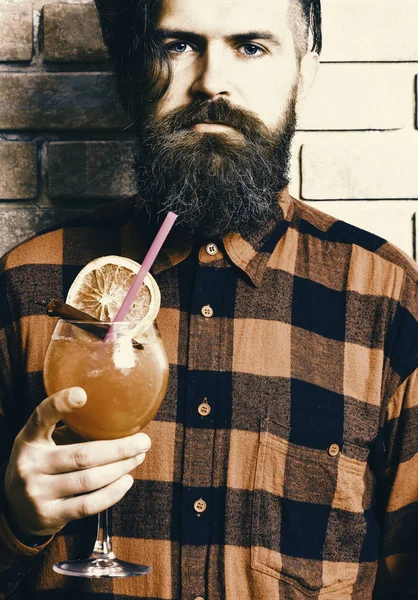 discount on cocktails. Man holds alcohol cocktail on brick wall background.
