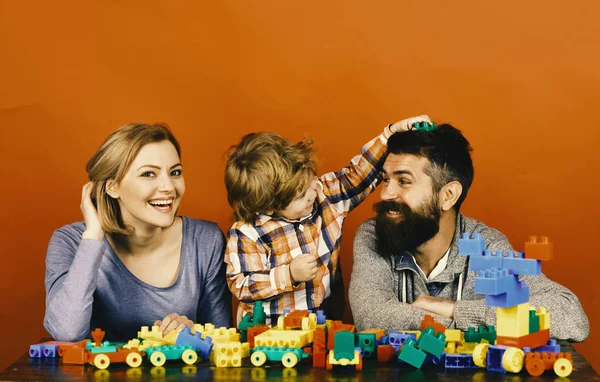 Ευτυχισμένη οικογένεια παιχνίδι. Άντρας με γένια, γυναίκα και αγόρι παιχνίδι σε κόκκινο φόντο — Φωτογραφία Αρχείου