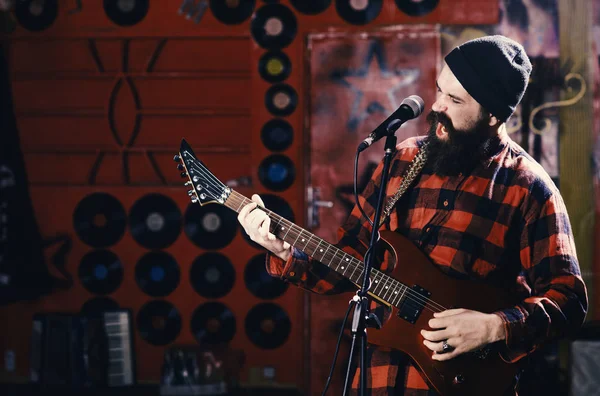 play guitar. Musician with beard play electric guitar instrument.