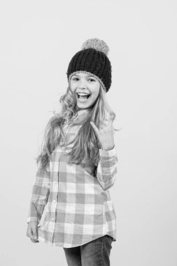 Şapkalı kız, turuncu arka planda ekose gömlek.