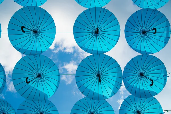 Los paraguas azules flotan en el cielo en un día soleado. Paraguas cielo instalación del proyecto. Fiesta y celebración del festival. Sombra y protección. Diseño y decoración de arte al aire libre —  Fotos de Stock