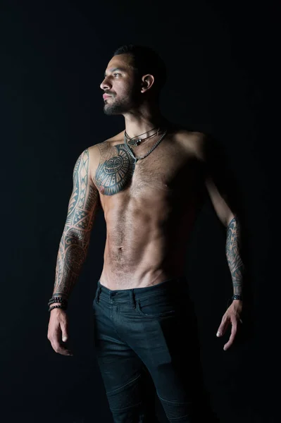 Cuidado com o corpo com fitness e esporte. Homem tatuado mostra torso muscular sexy. Esportista com seis maços e abdominais. Fisiculturista com bíceps e tríceps. Modelo de moda com tatuagem em jeans — Fotografia de Stock