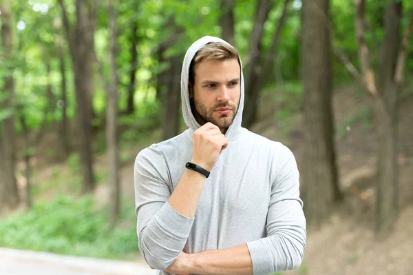 Sportsman training with pedometer gadget. Fitness tracker concept. Man athlete on pensive face with sport fitness gadget, nature background. Athlete with bristle with fitness tracker or pedometer — Stock Photo, Image