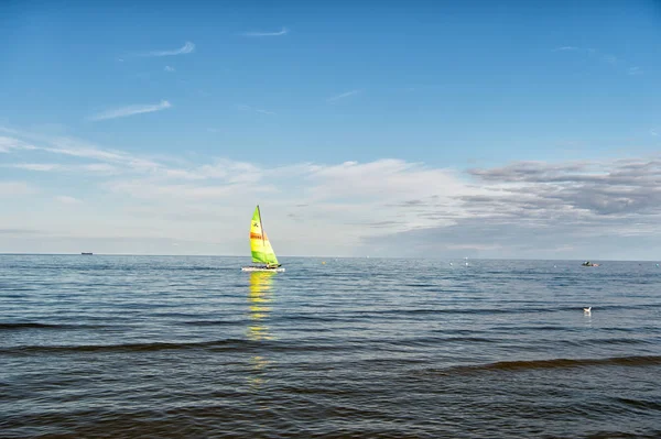 Sailing boat in sea of Gdansk, Poland. Sailboat with bright sail sailing on water on blue sky. Summer adventure and active vacation. Yacht sailing and wanderlust. Vessel and water transport — Stock Photo, Image