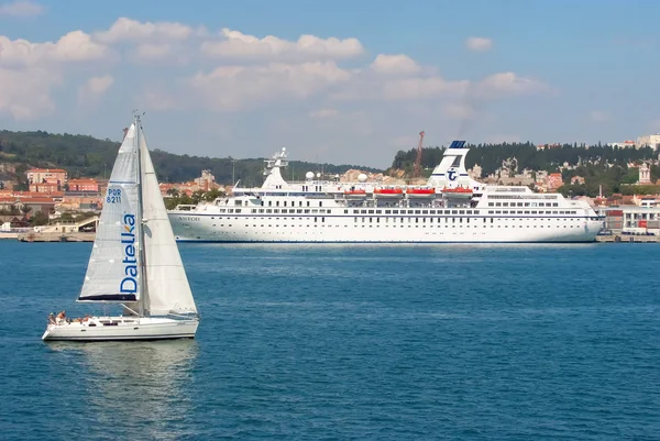Lisbon, Portugal - April 03, 2010: sailboat and ship on blue sea coast. Sailing boat and ocean liner in sea. Travelling for pleasure. Travel by water. Summer vacation and wanderlust — Stock Photo, Image