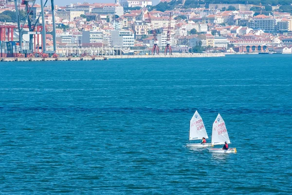 Lisabon, Portugalsko - 03 duben 2010: plachetnice v modrém moři na panoráma města. Regaty na slunečný den. Mistrovství republiky v jachtingu moře. Regatta a jachtě plující sport. Cestování po vodě s dobrodružství — Stock fotografie