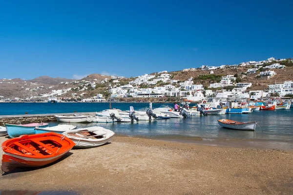 Mykonos, Greece - May 04, 2010: boats on sea beach. Village with white houses at blue sea on mountain landscape. Summer vacation on mediterranean island with adventure. Wanderlust and travelling — Stock Photo, Image