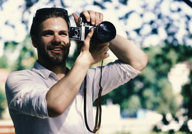 Fotoğrafçı çalışıyor. Yüz gülümseyen adam dışındaki resim alır. Fotoğrafçı kamera tutan