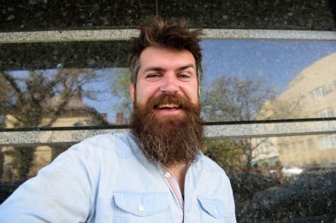 Adam, sakal ve bıyık neşeli, gülümseyen yüzünde siyah mermer zemin üzerine turist. Vlogging kavramı. Selfie fotoğrafta hipster, turist tousled saçlı ve uzun sakal kameraya, seyir