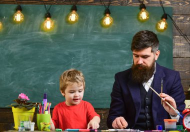 Baba sanatçı oğlu boyamak eğitmektir. Sarışın çocuk çizmek için öğrenme.