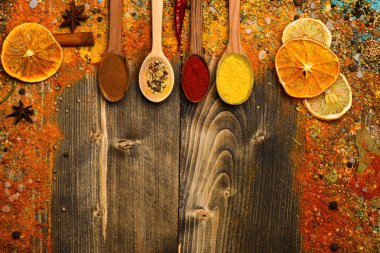 Baharat kavramı. Tarçın, öğütülmüş kırmızı biber ve curcuma tozu dolu kaşık ahşap arka planda, kopya alanı yatıyordu. Baharat tüm ahşap yüzey üzerinde dağınık. Ahşap doku baharat kaşıklarla