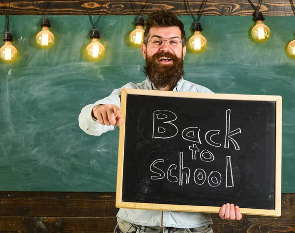 Gözlük öğretmen blackboard yazıt ile okula geri tutar. Geri okul kavramı. Adam sakal ve bıyık mutlu yüz davet öğrencilerin, ön, arka plan kara tahta işaret — Stok fotoğraf