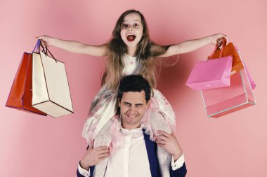Shopaholics, çocukluk ve Aile kavramı. Kız ve adam neşeli yüzü olan alışveriş torbaları tutun