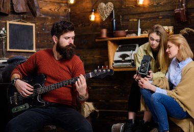 Elektrik gitar çalmak kesilmiş sakallı adam. Kırsal kesimde aile ile vakit müzisyen. Sakallı adam evde prova. Kızlar ünlü instrumentalis hakkında belgesel