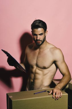 Seksi gövdeli adam kutuların arkasında çıplak duruyor..