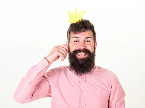 Fiesta de cumpleaños del hombre barbudo alegre, concepto de celebración. Hombre feliz con barba larga y gran sonrisa sosteniendo la corona de papel del conjunto de la fiesta. Hipster barbudo en camisa rosa posando con accesorios de papel —  Fotos de Stock