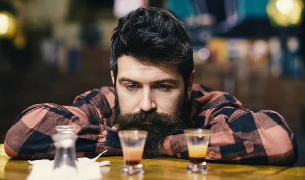 Депрессивный и грустный мужчина сидит один в баре или пабе — стоковое фото