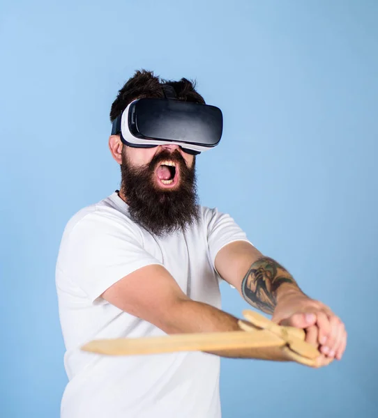 Conceito de jogador VR. Homem com barba em óculos VR, fundo azul claro. Hipster no rosto gritando desfrutar de jogar jogo na realidade virtual. Cara com cabeça montada exibição e espada jogar jogo de luta em VR — Fotografia de Stock