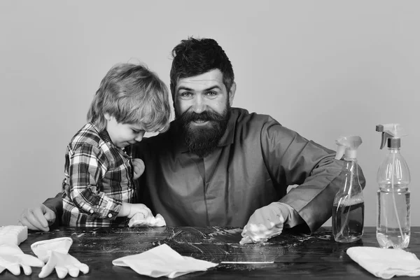Petit concept d'aide des parents. Homme avec sourire et enfant nettoyage ensemble table en bois . — Photo