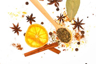 Baharat seti hazırlamak için mulled şarap ya da sıcak içecek, yakın çekim. Baharatlar, kurutulmuş portakal, tarçın, kakule ve beyaz zemin üzerine Hindistan cevizi kaşıkla. Baharat Seti kavramı. Sıcak içecekler baharat seti