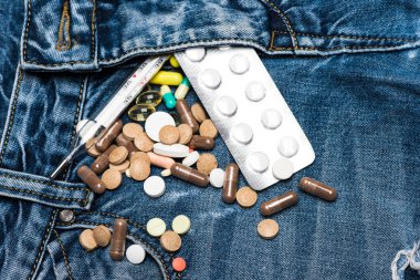 Renkli hapları ve cıva termometre ile Genitoüriner sistem bozuklukları sembolü olarak zip. İlaç veya ilaç tablet kot yakınındaki ZIP, denim arka plan üzerinde dağınık. Genitoüriner sorun kavramı