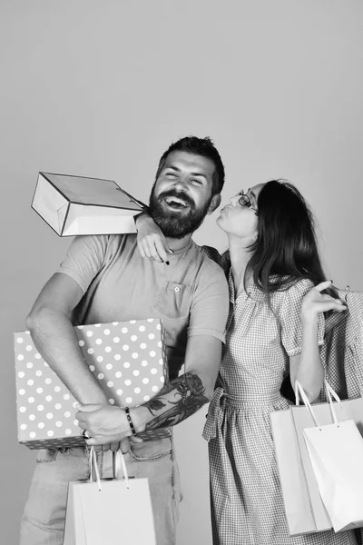 Money and shopping concept. Couple in love holds shopping bags, hugs and kisses — Stock Photo, Image