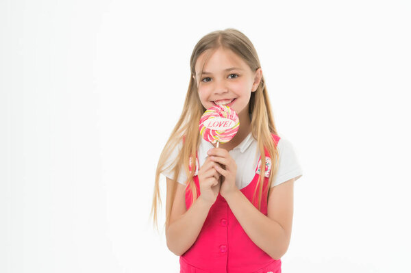 Девушка на улыбающемся лице держит в руке гигантский красочный леденец, изолированный на белом фоне. Парень с длинными волосами любит сладости и лакомства. Концепция сладкоежки. Девушка ест большие конфеты на палочке или леденец
