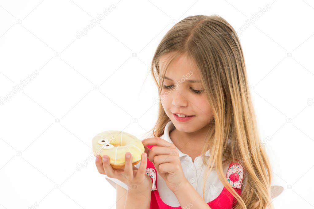 Sweet treasure. Girl calm face carefully holds sweet donut in hand, isolated white. Kid girl with long hair likes donuts. Snack concept. Child likes to eat donuts with colorful toppings, copy space