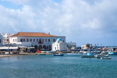 Mykonos, Yunanistan - 04 Mayıs 2010: Balıkçı tekneleri Denizi plajında. Bulutlu gökyüzü deniz köyünde. Kilise ve Yalı evleri. Adada tatil yaz. Yolculuk tutkusu ve kavram seyahat