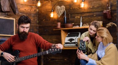 Maço acımasız yüzü elektro gitar tutuyor. Müzik aleti çalma sakallı adam. Yeni şarkı, müzik konsepti prova hipster sakallı adam. Kadın ve Genç kız müzikal performans kaydı
