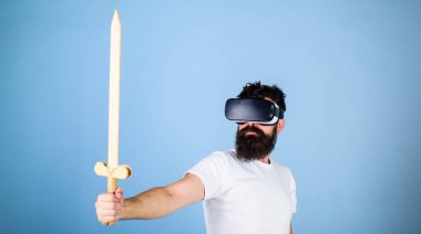 Oyun kavramı. Adam kafa monte görüntü tutar kılıç, Vr. Hipster oyunda ciddi yüz mücadele oyun ile zevk oyna sanal gerçeklik. Vr gözlük, açık mavi renkli sakallı