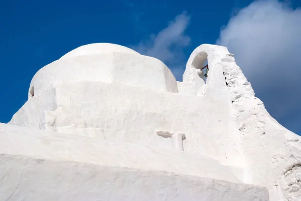 Dome and bell tower of Panagia Paraportiani church in Mykonos, Greece. Chapel building architecture. White church on cloudy blue sky. Religion and cult concept. Vacation on mediterranean island — Stock Photo, Image