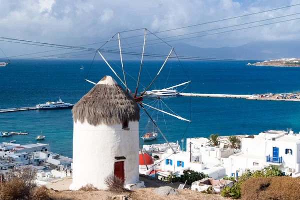 Windmill on seascape in Mykonos, Greece. Windmill on mountain by sea on sky. Whitewashed building with sail and straw roof with nice architecture. Summer vacation on island. Landmark and attraction — Stock Photo, Image