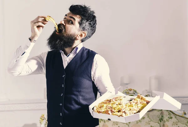 Pizza teslim kavramı. Sakal ve bıyık teslim tutar kutusu lezzetli taze sıcak pizza ile olan adam. Dilim pizza yeme, beyaz arka plan, maço klasik giysiler aç neşeli yüzünde ısırıkları — Stok fotoğraf