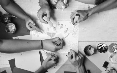 Eller renkli kalemleri tutar ve çocukların resimlerini çizer.