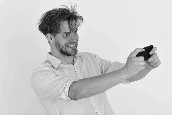 Hombre con el pelo elegante y la cara sonriente sostiene el teléfono móvil. Macho con celular sobre fondo blanco. Concepto de comunicación — Foto de Stock