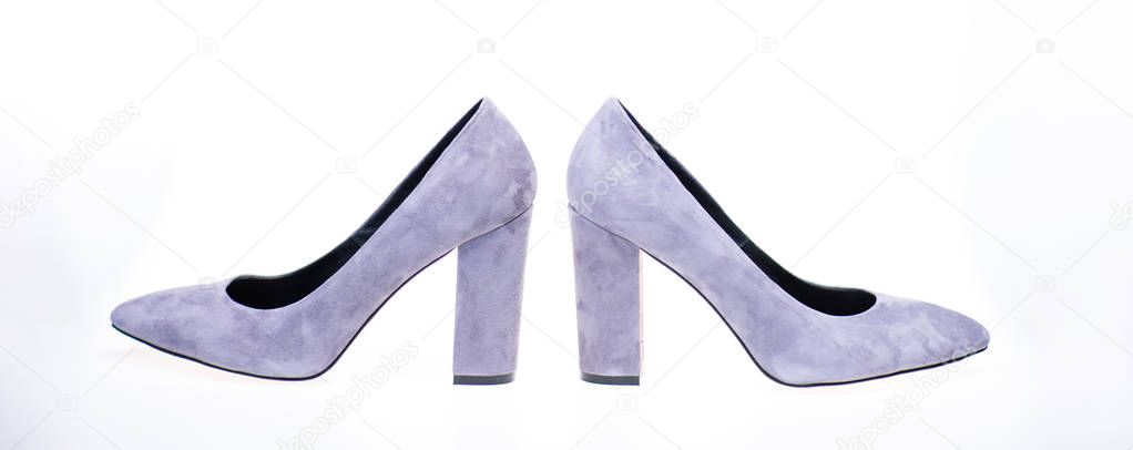 Shoes made out of grey suede on white background, isolated. Footwear for women with thick high heels, side view. Female footwear concept. Pair of fashionable high heeled shoes
