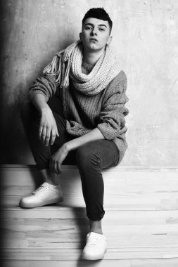 Gri süveter ve eşarplı yakışıklı genç adam.