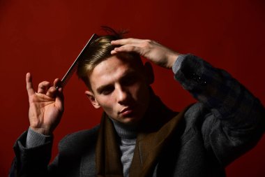 Stilist ciddi bir yüz ile saç modeli yapar. Vintage tarzı erkekte