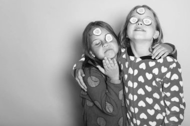 Gülümseyen yüzler, gözleri ve bağsız kıl salatalık ile çocuk. Çocukluk ve mutluluk kavramı. Renkli kızlarda polka noktalı pijama