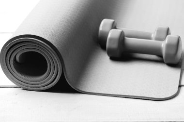 Spor ve sağlıklı yaşam konsepti. Şekillendirme ve fitness ekipmanları. Hafif ahşap zemin üzerine yeşil plastik dambıl