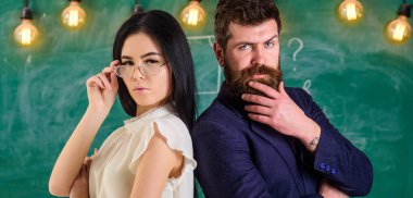 Sakal ve gözlük stand sırt sırta, kara tahta arka plan öğretmen olan adam. Öğretmen ve öğretmen rahat görünüyor. Bayan ve birlikte okulda çalışan hippi. Ekip çalışması kavramı