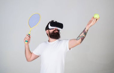Sanal gerçeklik kulaklık tenis oynuyor, yakışıklı adam arka plan gri. Yenilikçi spor oyunları için modern teknolojisini kullanıyor. Vr gözlüklü play tenis raket ve top ile. Sanal Tenis kavramı