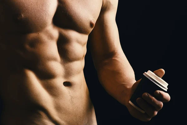 Guys abs and strong chest. Sports, ad, bodybuilding and healthy nutrition concept. Athletes body in close up, hand holding coffee cup